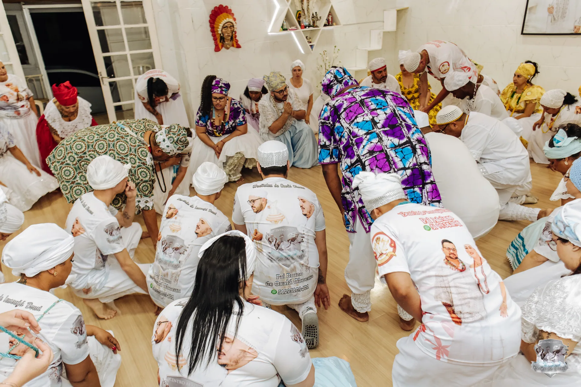 Momento de recolhimento — comunidade ajoelhada em círculo no ritual da nação